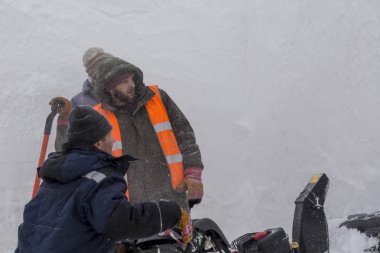 İşçiler kar tipide bir kar temizleme aracı kullanarak kaldırın.