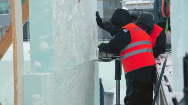 Рабочий режет ледяную панель бензиновой пилой — стоковое видео