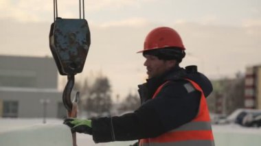 Buz blokları boşaltma da yükleyici Portresi Turuncu yansıtıcı yelek ve bir kask boşaltma buz panelleri bir montajcı işçi portresi