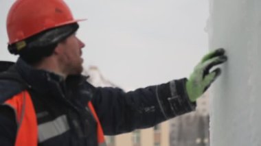Buz panelinde yükleyici portresi Buz paneli tarafından turuncu yansıtıcı yelek ve kask bir montajcı işçi portresi