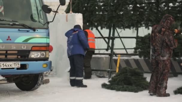 労働者は氷の町を建設し クリスマスツリーを飾る — ストック動画
