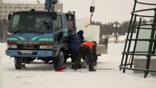 从汽车总成上卸下冰块的工人用起重机从汽车上卸下冰块 — 图库视频影像