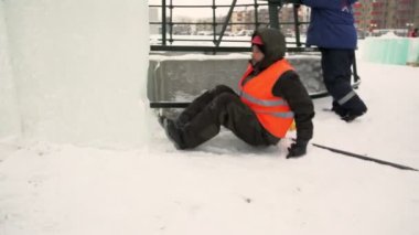 Montajcılar yüksek buz bloklarına ladin koyarlar buz kasabasının inşaatçıları Noel ağacını yüksek buz panelleriyle kaplarlar.