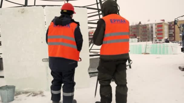 Tre Arbetare Installationsplatsen För Ice Town Bakgrunden Julgran Uppbyggnad — Stockvideo