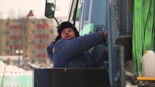 職場での油圧マニピュレータのドライバー 氷の町の建設時の油圧クレーンドライバーの肖像 — ストック動画