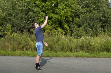 Elinde raket olan genç bir çocuk badminton oynar.