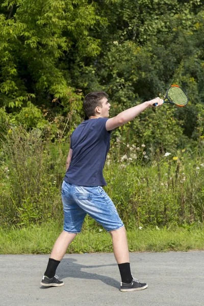 Adolescente chico con una raqueta en la mano juega bádminton — Foto de Stock