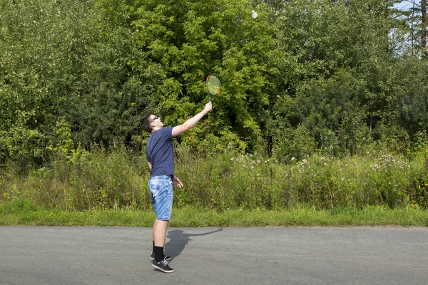 Adolescente chico con una raqueta en la mano juega bádminton — Foto de Stock