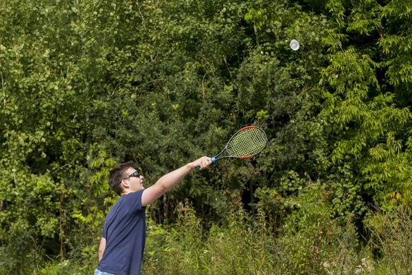 Adolescente chico con una raqueta en la mano juega bádminton — Foto de Stock