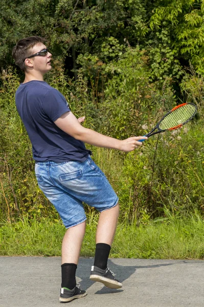 Jeune garçon avec une raquette dans la main joue au badminton — Photo