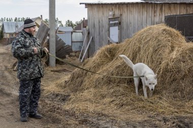 Tulumlu bir adam köpekle yürüyüşe çıkıyor.