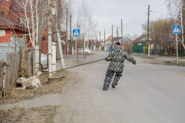 Tulumlu bir adam köpekle yürüyüşe çıkıyor.