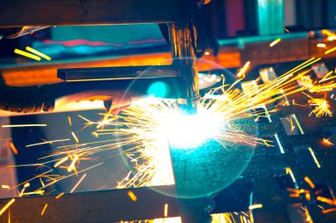 Plazma kesme makinesi, erimiş metal damlalarını farklı yönlere saçarak kalın bir çelik tabakayı yakar.