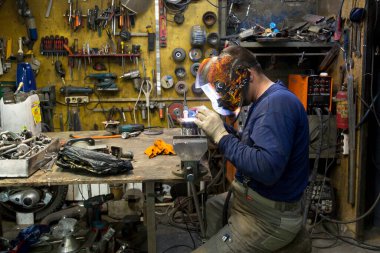 TIG kaynakçısı yolcu vagonunun egzoz sistemi için kaynak yapıyor.