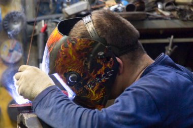 TIG kaynakçısı yolcu vagonunun egzoz sistemi için kaynak yapıyor.