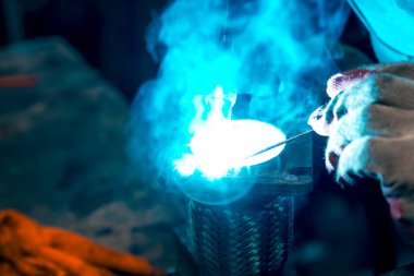 TIG kaynakçısı yolcu vagonunun egzoz sistemi için kaynak yapıyor.