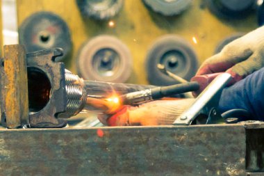 TIG kaynakçısı yolcu vagonunun egzoz sistemi için kaynak yapıyor.