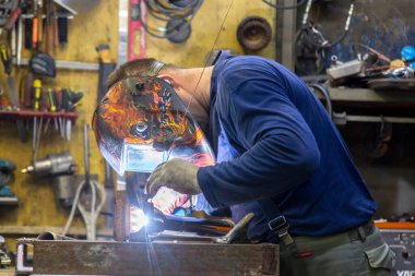 TIG kaynakçısı yolcu vagonunun egzoz sistemi için kaynak yapıyor.