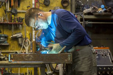 İş yerinde kafasında kask olan bir argon kaynakçı portresi.