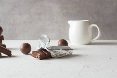 Beyaz masada çikolata şekerler ve ısırılmış barlar. Metin için bir yer. 