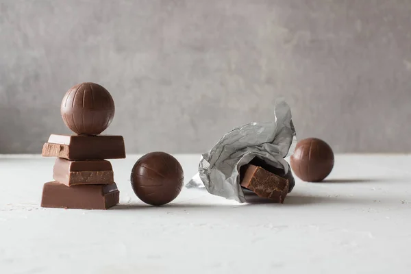 Beyaz masada çikolata şekerler ve ısırılmış barlar. Metin için bir yer. 
