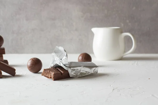 Beyaz masada çikolata şekerler ve ısırılmış barlar. Metin için bir yer. 