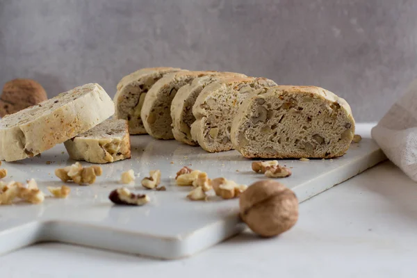 Beyaz rustik kesme tahtasında fındık ile ev yapımı İtalyan bisküvi yakın yukarı. Sağlıklı ev yapımı gıda konsepti 