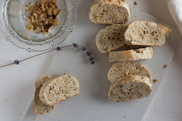 Beyaz rustik kesme tahtası üst görünümünde fındık ile ev yapımı İtalyan bisküvi. Sağlıklı ev yapımı gıda konsepti 