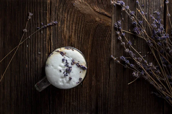 Arka planda lavanta dallar ile şeffaf bardak lavanta latte veya raf kahve düşük anahtar fotoğraf, yakın yukarı, arka ışık. Trendy koyu ve Moody tarzı