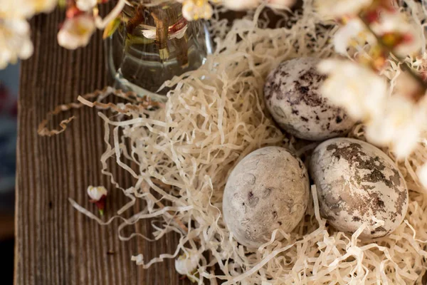パスカルは暗い木製のテーブルの巣に着色された卵を作りました イースターデコレーション — ストック写真