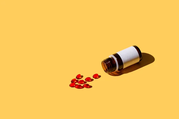 Vitaminler Bir Sağlıyor Kırmızı Kapsül Sarı Zemin Üzerine Bir Şişe — Stok fotoğraf