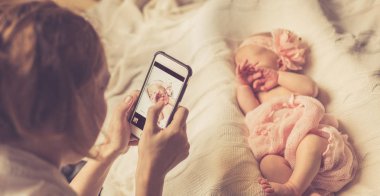 Anne yeni doğan kızı pembe bir kafa bandı başında bir çiçek ve üzerinde beyaz Örgü Battaniye Uyku bir taç ile bir yumuşak pembe Battaniyeyle sarılmış fotoğraflar. Seçici odak