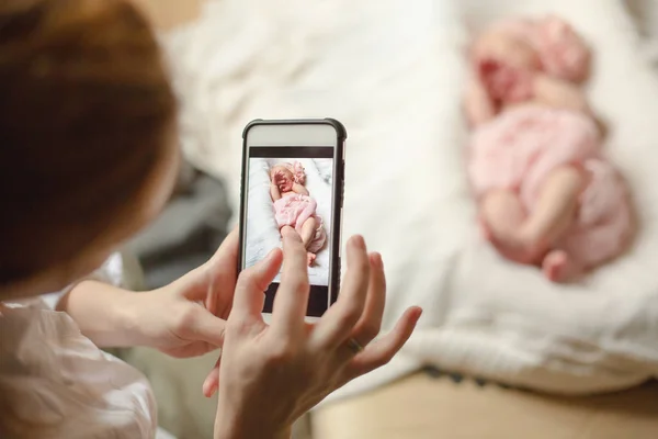 Kobieta Trzyma Smartphone Robi Zdjęcie Noworodka Dziewczynka Spanie Biały Koc — Zdjęcie stockowe