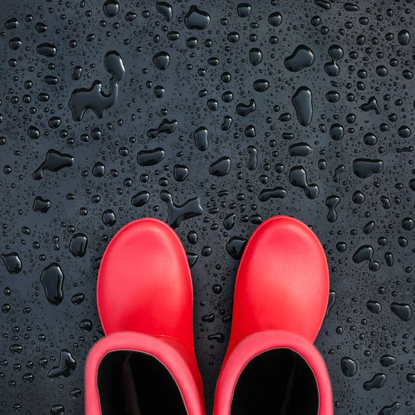 Trendy Κόκκινο Λαστιχένιες Μπότες Μαύρο Υγρή Επιφάνεια Καλυμμένη Σταγόνες Βροχής — Φωτογραφία Αρχείου