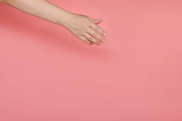 Die Weibliche Hand Auf Rosa Hintergrund Erstreckt Sich Etwas Diagonal — Stockfoto