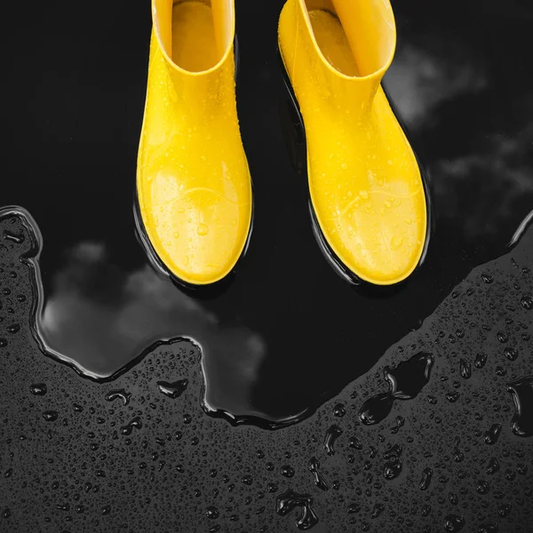 Yellow Rubber Boots Stand Puddle Which Clouds Reflected Black Background — Stock Photo, Image