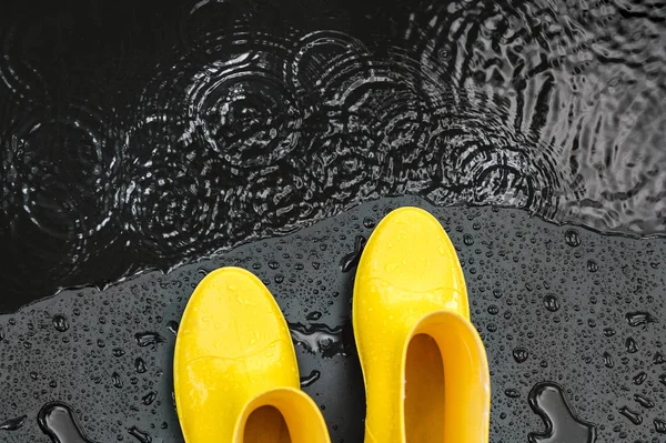 Women Bright Yellow Rubber Boots Stand Raindrops Black Background Front — Stock Photo, Image
