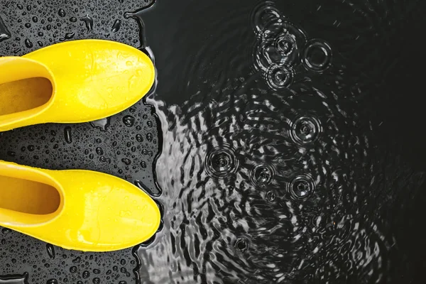 Κίτρινο Γυαλιστερό Gumboots Περίπτερο Στη Βροχή Μαύρο Φόντο Που Καλύπτεται — Φωτογραφία Αρχείου