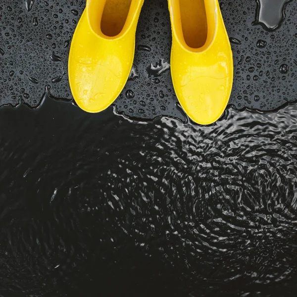 Women Bright Yellow Rubber Boots Stand Raindrops Black Background Front — Stock Photo, Image