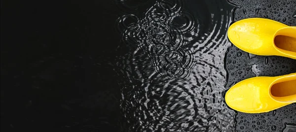 Die Knallgelben Gummistiefel Der Frauen Stehen Unter Regentropfen Auf Schwarzem — Stockfoto