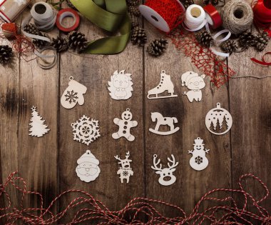 Şeritler, kordon, halatlar ve çam kozalakları çevrili bir ahşap masa üzerinde çeşitli ahşap Noel oyuncaklar (mitten, yılbaşı ağacı, kar tanesi, domuz, geyik, kardan adam, at, Noel Baba, zencefilli kurabiye adam ve diğerleri) bir dizi yatıyor. Noel ve yeni Y için hazırlanıyor