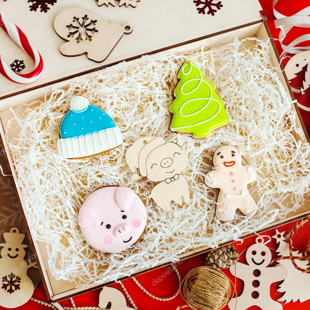 A box with wooden toys and gingerbread in the form of a gingerbread man, a pig, a Christmas tree and a hat.