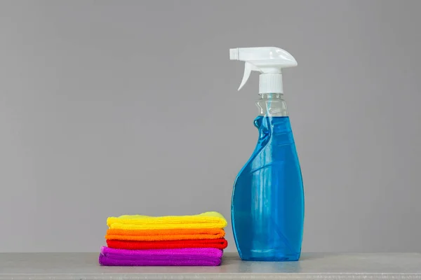 A set of colorful cleaning clothes and a cleaning agent in a spray bottle. Place for text. Concept  spring cleaning.