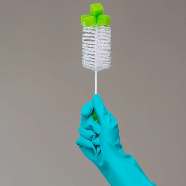 ゴム手袋で手は 中立的な背景の食器洗いブラシを保持します 明るい春 春の大掃除の概念 — ストック写真