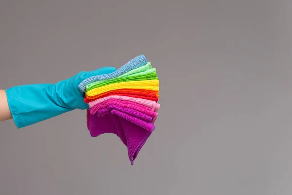 一只手在橡胶手套举行一套彩色的超细纤维布上的中性背景 明亮的春天的概念 春季清洁 — 图库照片