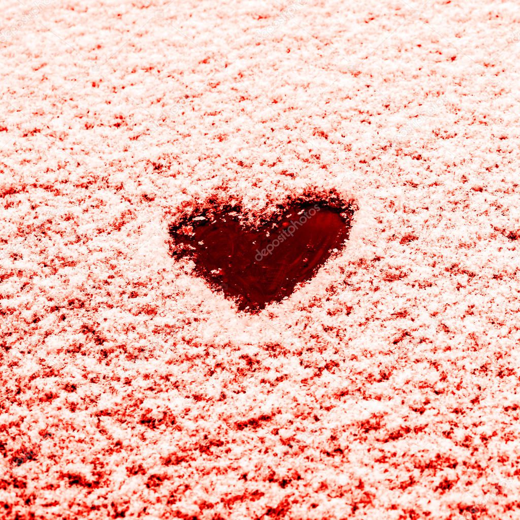Heart painted on the snow-covered windshield of a car. Copy space. 