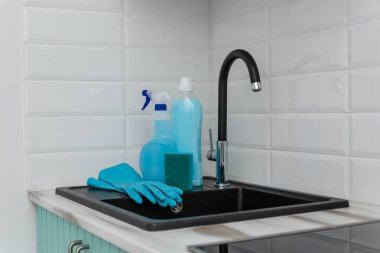 Evye mavi temizlik ürünleri ve mutfağı temizlediğin için araçlar kümesidir.