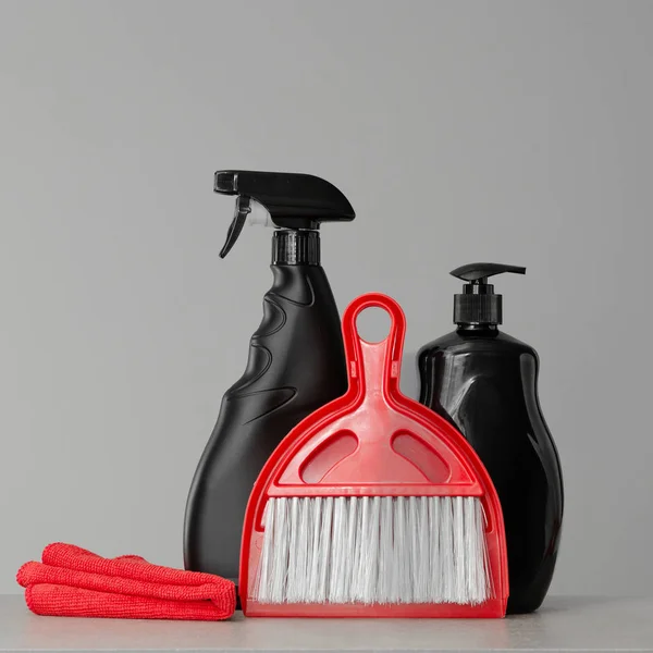 Schwarze Reinigungsprodukte Und Rote Reinigungswerkzeuge Auf Neutralem Hintergrund Kopierraum — Stockfoto