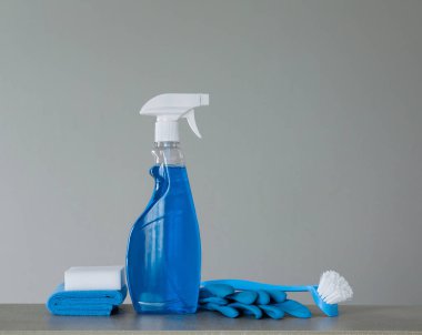 Mavi püskürtülen ilaç şişe ile plastik Sabunluk, yemek, bez için kutular, sünger ve lastik eldiven için fırça gri arka plan üzerinde ovma temizlik. Boya, vernik. Kopya alanı.