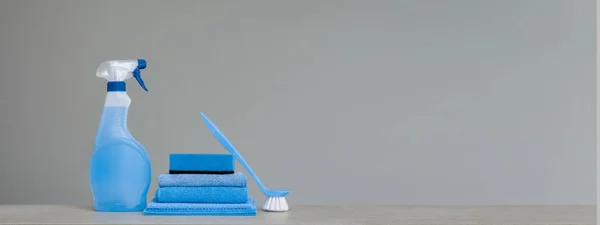 Mavi püskürtülen ilaç şişe Plastik Sabunluk ile temizlik, sünger, yemek için fırça ve bez toz için gri arka plan üzerinde ovma. Temizlik araçları. Kopya alanı.